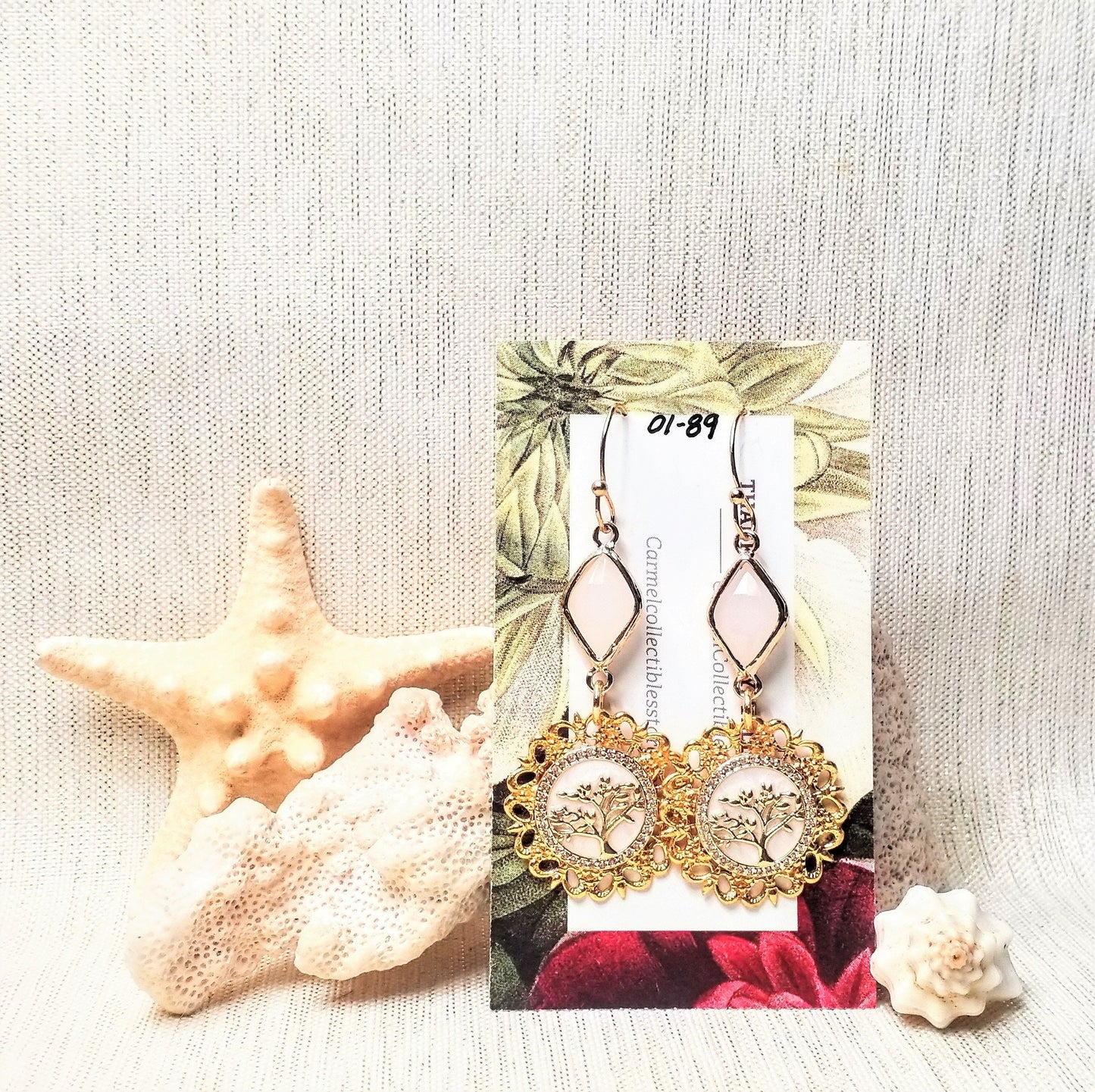 Here is a simple elegant tree of life design earring set for you. Gold plated ear wires for comfort hold matte white diamond connectors to circles of golden filigree with thin rhinestones that circle the delicate golden branching tree on white back.